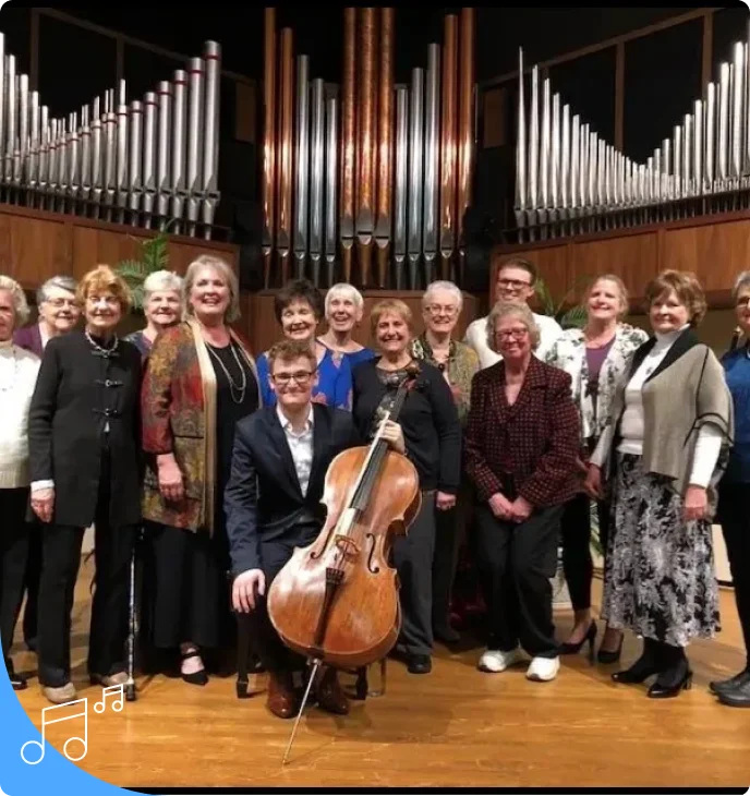 A group of people standing in front of an organ.