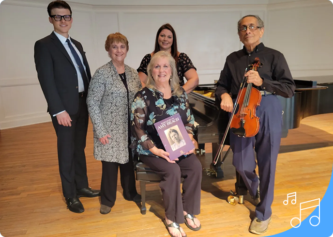 A group of people standing around a piano.