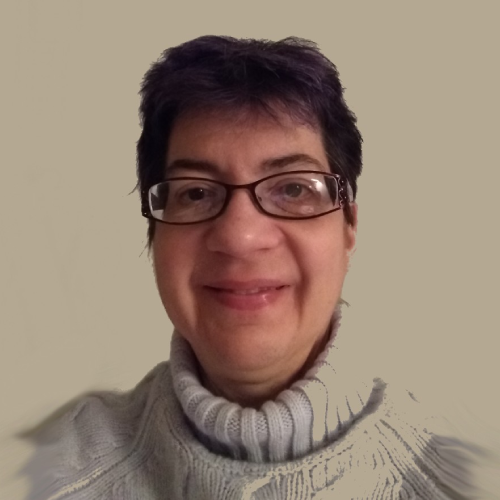 A woman with short hair wearing glasses and a sweater.