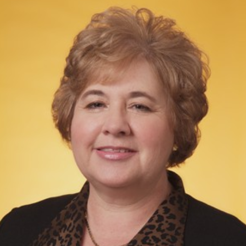 A woman with blonde hair and wearing a leopard print shirt.